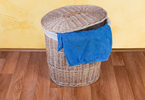 Cesta de ropa de mimbre de madera en el suelo y toalla de baño colgante — Foto de Stock