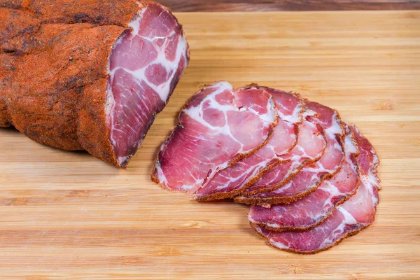 Teilweise in Scheiben geschnittener Schweinehals auf Holzschneidebrett — Stockfoto