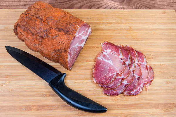 Cuello de cerdo curado en rodajas parciales y cuchillo en la tabla de cortar —  Fotos de Stock