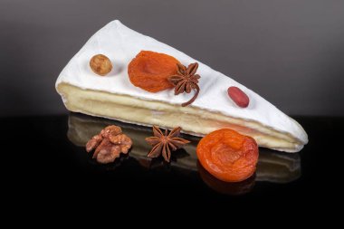 Krem peynir, fındık, koyu renkli yansıtıcı yüzeyde kurutulmuş meyve.