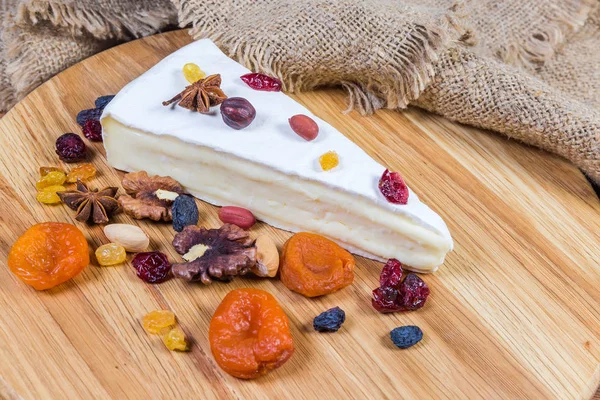 Queso brie entre frutos secos y frutos secos de cerca — Foto de Stock