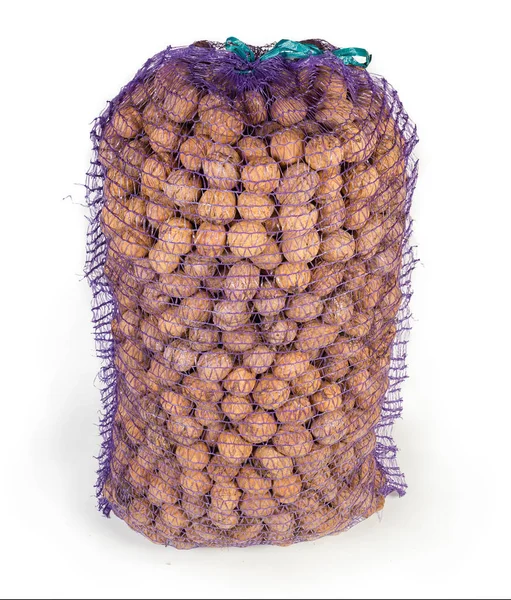 Zralé vlašské ořechy ve velkém plastovém síťovaném sáčku — Stock fotografie