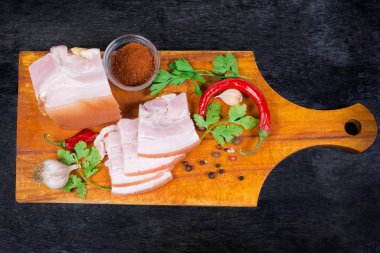 Dilimlenmiş kaynamış domuz göbeğiyle kesme tahtası.