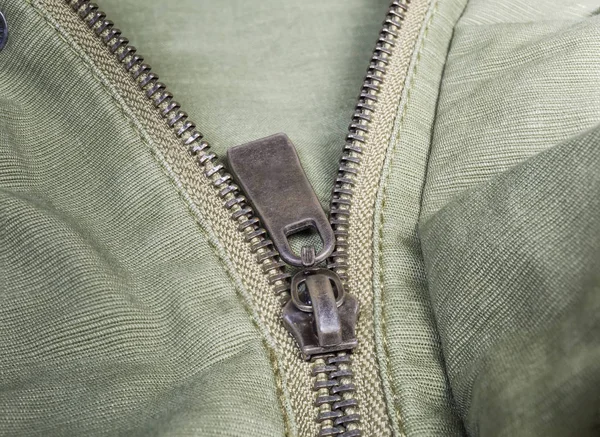 Fragment of metal zipper on outerwear olive color close-up — Stock Photo, Image