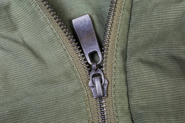 Fragment of metal zipper on outerwear olive color close-up — Stock Photo, Image