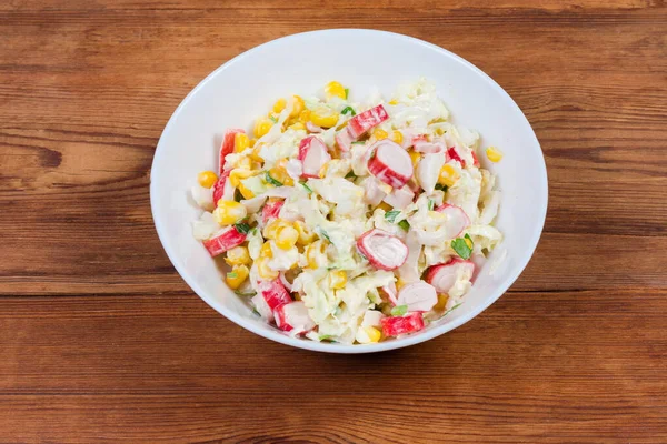 Crab sticks salad with vegetables in bowl on rustic table — Stock Photo, Image