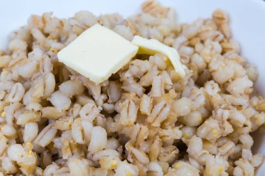 Seçici odaklı tereyağlı inci arpa lapası.