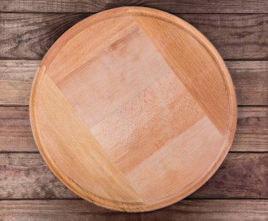 Boş yuvarlak ahşap pizza tahtası, kırsal masa, üst manzara.