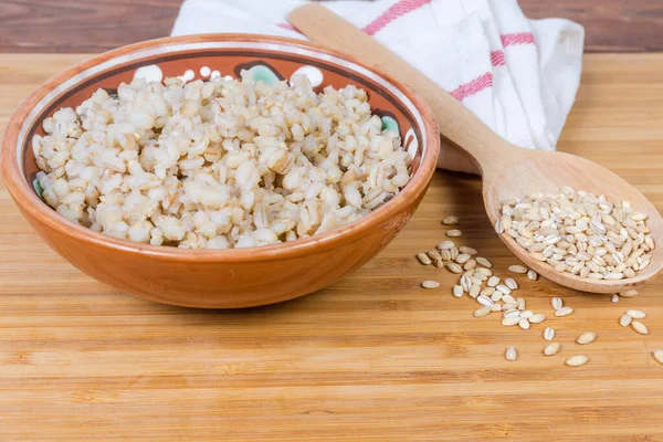 ボウルに真珠大麦のお粥、調理されていない真珠大麦のクローズアップ — ストック写真