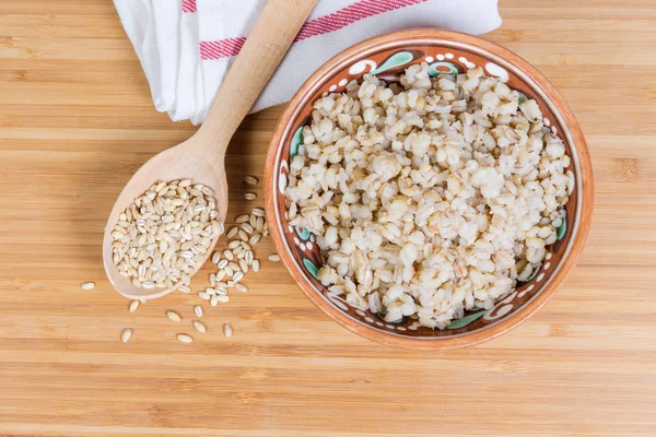 真珠の大麦のお粥と調理されていない真珠の大麦の穀物、トップビュー — ストック写真