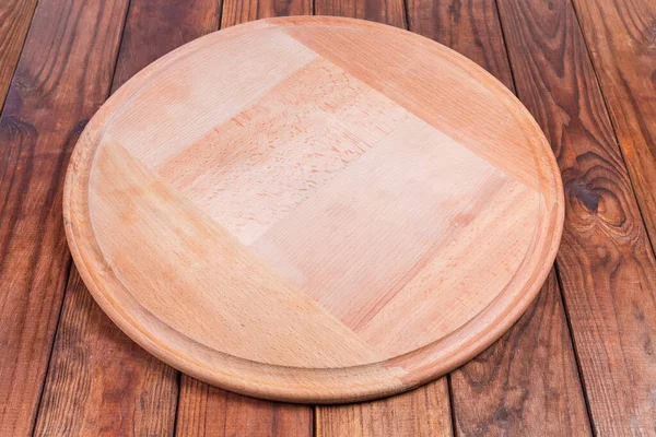 Prázdná kulatá dřevěná pizza deska na rustikálním stole — Stock fotografie