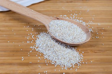 Çiğ arpa, tahta kaşıkta homurdanıyor. Tahta bir yüzey üzerinde. Seçici bir odak noktasında yakın plan.