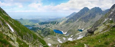 Tatra Dağları 'ndaki sarp kayalıklarla çevrili dağ vadisi, tepenin panoramik manzarası.