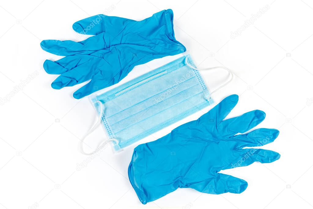 Blue disposable medical face mask and pair of nitrile powder free medical gloves on a white background, top view