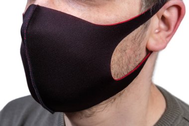 Elastik siyah koruyucu kumaş maske takıyor.