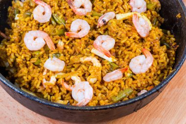 Ahşap kaplama üzerinde pişmiş deniz ürünleri paella ile kızartma tavasının bir parçası.