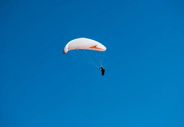在蓝光天空中的滑翔伞的下降 — 图库照片