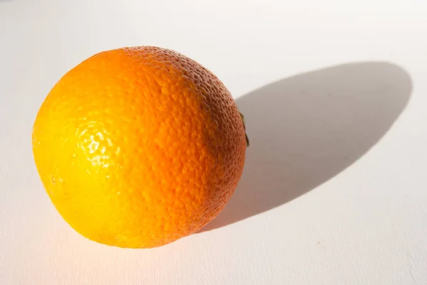 Single orange with its shadow in a white background — Stock Photo, Image