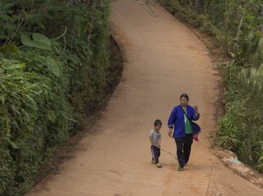 Yükseltilmiş yol üzerinde Chiang Rai, Tayland oğlu ile yürüyen kadın görünümünü