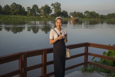 Lakeside adlı, Chiang Rai, Tayland duran mutlu kadın