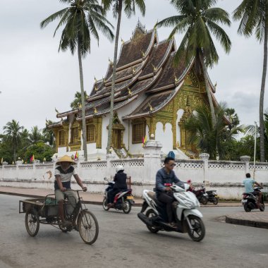 Arka planda, Royal Tapınağı ile yolda araç sürme insanlar Haw Pha Bang, Luang Prabang, Laos