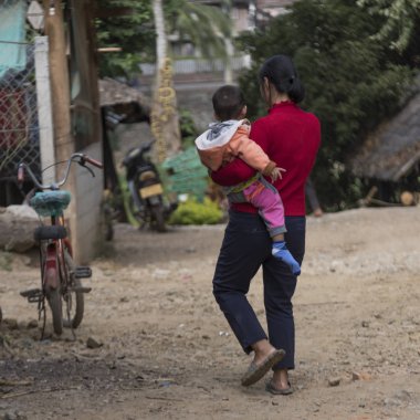 Kadın çocuğunu Luang Prabang, Laos, arkadan görünüş
