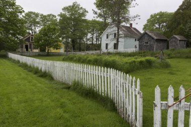 Picket fence by houses in village, Sherbrooke, Nova Scotia, Canada clipart