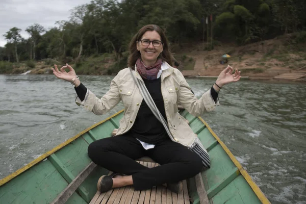 Portrait of happy woman sitting on boat in Nam Khan river, Luang Prabang, Laos