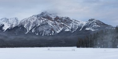 Arka planda, dağ silsilesi ile göl donmuş piramit Gölü, Otoban 16, Yellowhead Otoban, Jasper, Jasper National Park, Alberta, Kanada