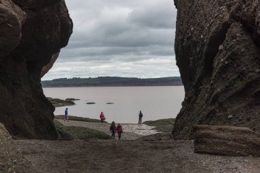 Tourists on beach at Hopewell Rocks, Bay of Fundy, New Brunswick, Canada clipart