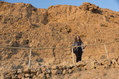 Low angle view of happy girl at abandoned fort, Masada, Judean Desert, Dead Sea Region, Israel clipart