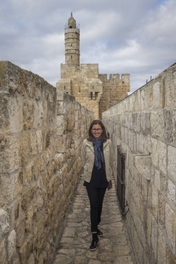 Happy woman standing in wall promenade in the old city with Tower of David in background, Jerusalem, Israel clipart