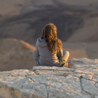Çölde, Makhtesh Ramon, Negev Çölü, İsrail kayaya oturan genç kız görünümünü