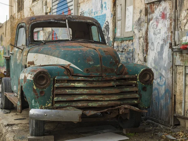 Abandoned car parked outside old building, Florentin, Tel Aviv, Israel