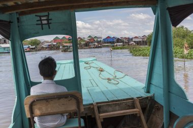 Tonle Sap Gölü, Kampong Phluk, Siem Reap, Kamboçya'nın üzerinde oturan adam arka görünümü