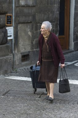 Bir alışveriş sepeti bir sokakta, Orvieto, Terni eyaletinde, Umbria, İtalya çekerek kadın kıdemli