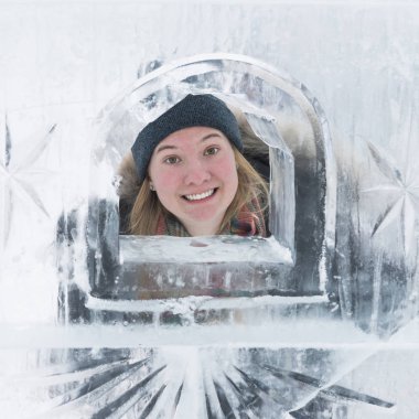 Woman looking through opening in ice castle wall, Banff National Park, Alberta, Canada