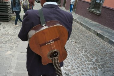 Rear view of a man with guitar on a street, San Miguel de Allende, Guanajuato, Mexico clipart