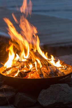 arka planda günbatımı sahilde kamp ateşi
