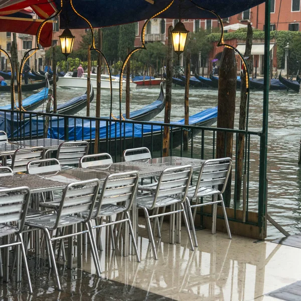 Chairs and tables at sidewalk cafe on Grand Canal, Venice, Veneto, Italy