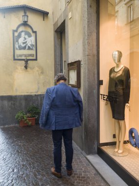 Arka görünümü bir adam ayakta bir giyim mağazası dışında Orvieto, Terni eyaletinde, Umbria, İtalya