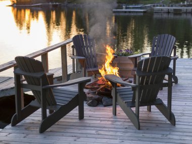 Adirondack sandalyeler ve kamp ateşi üstünde bir rıhtım, Lake of The Woods, Ontario, Kanada