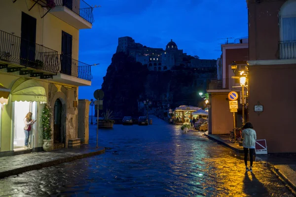 View of wet street at night, Aragonese Castle, Ischia Island, Campania, Italy