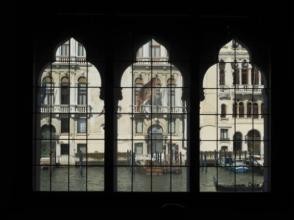 Houses by canal with boats seen through window, Venice, Veneto, Italy