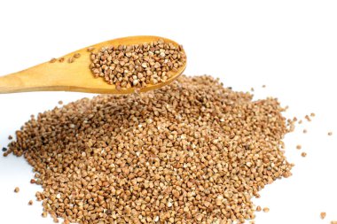 karabuğday kabuğu çıkarılmış tane beyaz zemin üzerine bir kaşık üzerinde