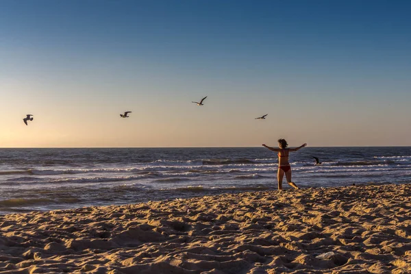 Sahilde Portekiz Atlantik Okyanusu üzerinde çalışan kırmızı mayo içinde bir kadın arkadan görünüş