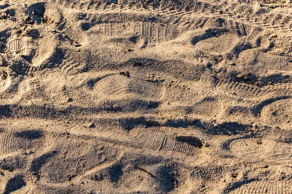 Uma textura horizontal de areia amarela com pegadas de sapatos — Fotografia de Stock