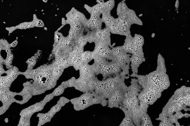 Köpüren beyaz köpüğün yatay dokusu siyah bir arka plan üzerindedir