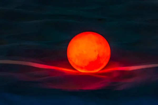Bela bola laranja ardente brilhante se parece com o sol no pôr do sol no mar — Fotografia de Stock