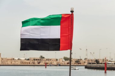 Deniz kıyısında bir dikdörtgen renkli bayrak.